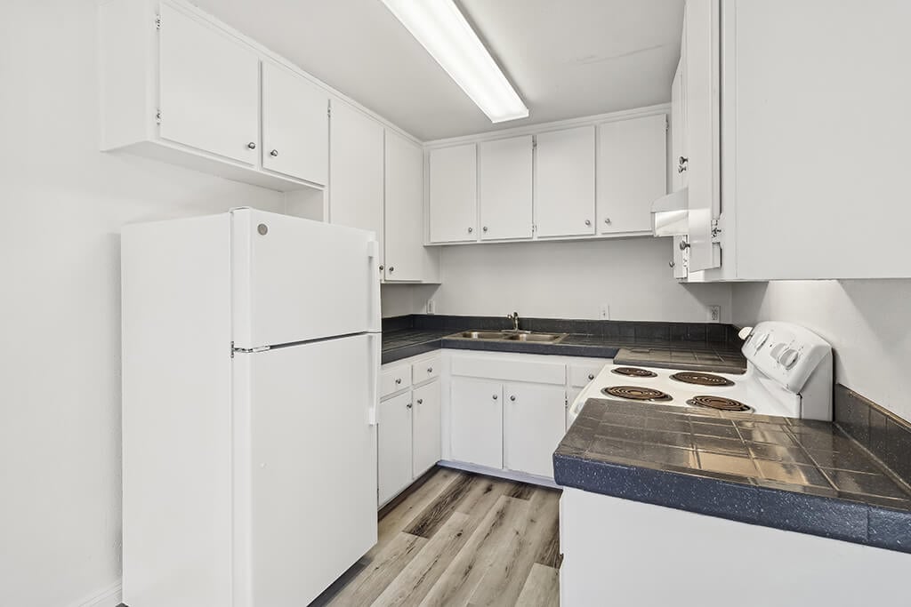 The corner of a bright, white kitchen at the Stratton Apartment Homes in San Diego, California.